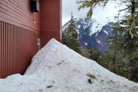 Snow against the mountain house